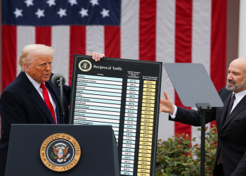 Tổng thống Donald Trump giơ bảng cho thấy mức thuế đối ứng mà Mỹ đánh lên hàng loạt quốc gia hôm 2-4, cạnh ông là Bộ trưởng Thương mại Howard Lutnick - Ảnh: REUTERS