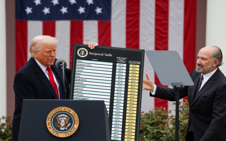 Tổng thống Donald Trump giơ bảng cho thấy mức thuế đối ứng mà Mỹ đánh lên hàng loạt quốc gia hôm 2-4, cạnh ông là Bộ trưởng Thương mại Howard Lutnick - Ảnh: REUTERS